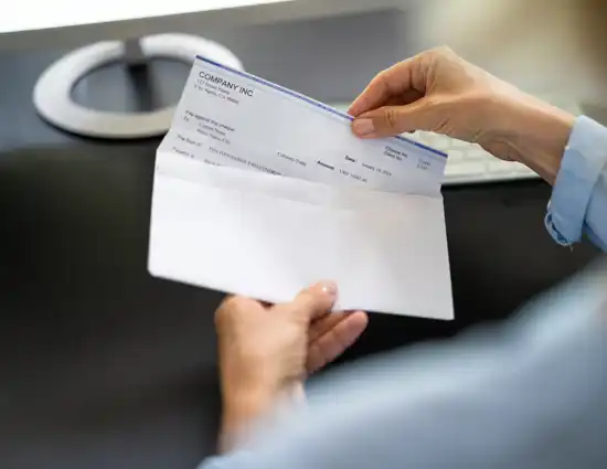 Business owner pulls paper check out of envelope